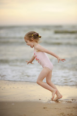 Little girl playing on a beach © MNStudio