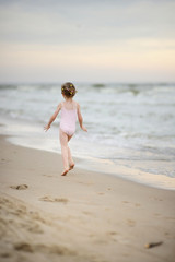 Fototapeta na wymiar Little girl playing on a beach