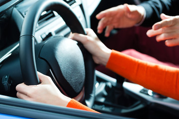 Frau in einem Fahrschule Auto macht Führerschein