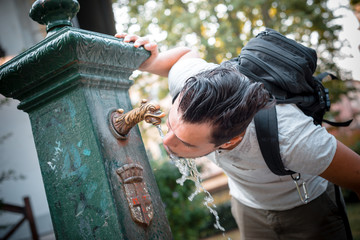 stylish man refreshing at the fountain