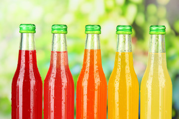 Bottles with tasty drinks on bright background