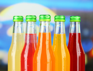 Bottles with tasty drinks on bright background