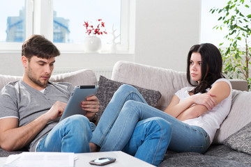 Obraz premium young couple in conflict, a guy with a tablet