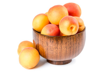 Ripe apricots in a wooden bowl