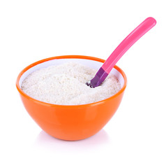 Powdered milk in bowl and spoon for baby isolated on white