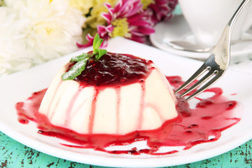 Panna Cotta with raspberry sauce, on color wooden background