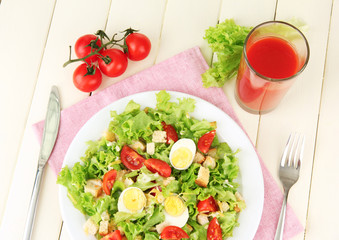 Caesar salad on white plate, on color wooden background