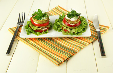 Tasty roasted marrow and tomato slices with salad leaves,