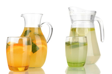 Orange and lemon lemonade in pitchers and glasses isolated