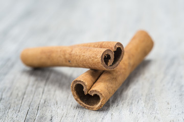 Palitos de canela en rama sobre un fondo de madera.