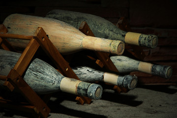 Old bottles of wine in old cellar, on dark  background