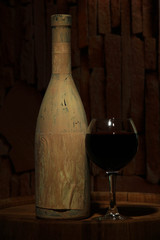 Composition with old bottle of wine and wineglass in old