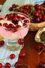 Delicious cherry dessert in glass vase on wooden table close-up