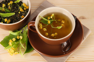 Cup of tea with linden on napkin   wooden table