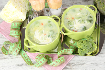 Cabbage soup in plates on metal tray on napkin on wooden table