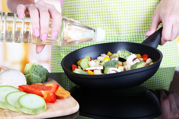 Hands cooking vegetable ragout in pan in kitchen