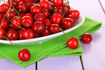 Cherry berries in bowl on wooden table close up