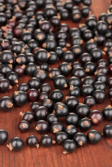 Fresh black currant on wooden background