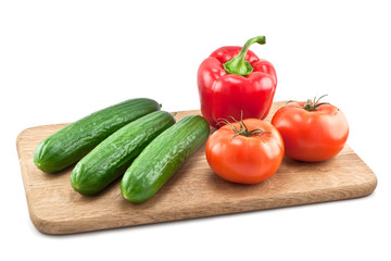 Fototapeta na wymiar cucumbers, tomatoes and peppers on wooden board