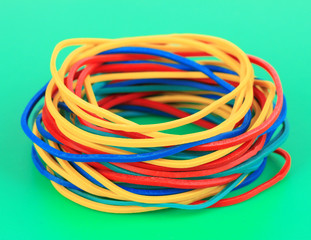 Colorful rubber bands on green background