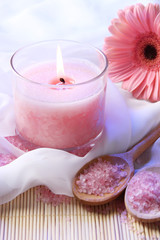 Beautiful candle with flower on white cloth, close up