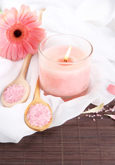Beautiful pink candle with flower on bamboo mat