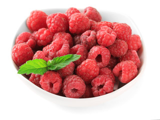 Ripe sweet raspberries in bowl, isolated on white