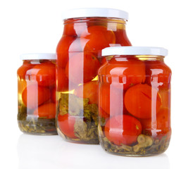 Tasty canned tomatoes in glass jars, isolated on white
