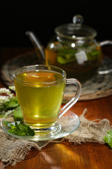 Cup and teapot of herbal tea with fresh mint flowers