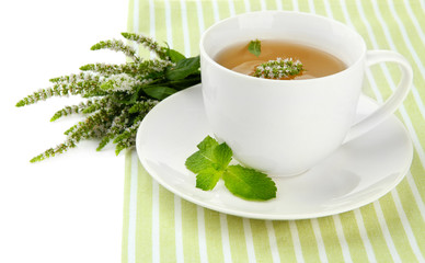 Cup of herbal tea with fresh mint flowers isolated on white