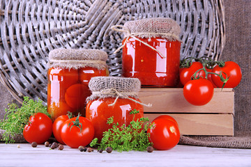 Tasty canned and fresh tomatoes on wooden table