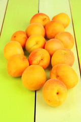 Naklejka na ściany i meble Fresh natural apricot on green wooden table