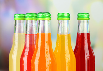 Bottles with tasty drinks on bright background
