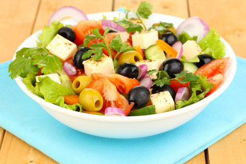 Fresh salad in plate on wooden table