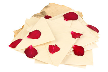 Pile of old letters with dried rose petals isolated on white