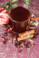 Herbal tea in glass cup, on color wooden background