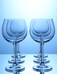 Empty wine glasses arranged on blue background