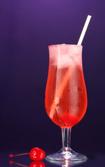Cherry cocktail with ice on dark purple background
