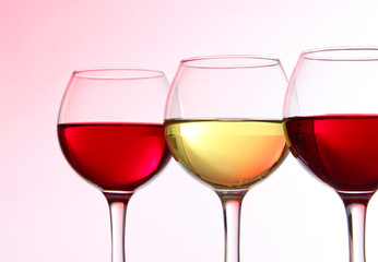 Glasses of wine on light pink tone