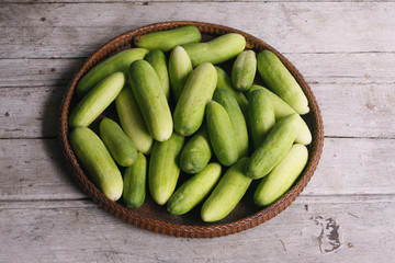 Cucumbers in the threshing basket on wooden table