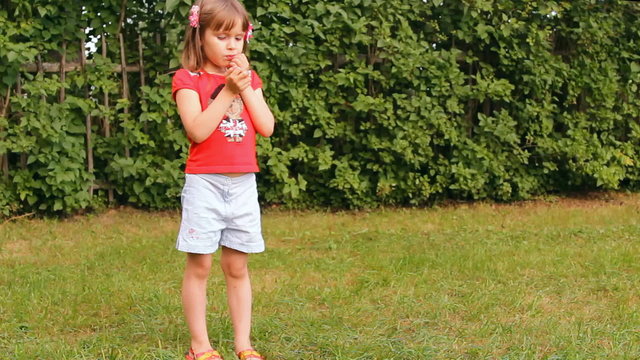 девочка ест яблоко на улице, лето, зелёная трава