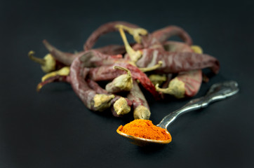 Chili peppers and powder in spoon isolated