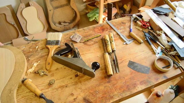 Luthier sanding a guitar, pan
