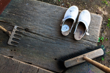 Clogs broom string rake wooden porch shoes