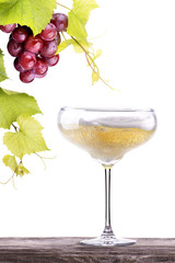 grapes  with glass of champagne on a table