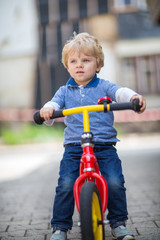 Fototapeta na wymiar 2 years old toddler riding on his first bike