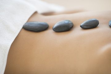 Woman Getting Hot Stone Therapy At Spa