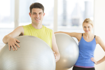Obraz premium Man And Woman With Pilates Smiling In Health Club