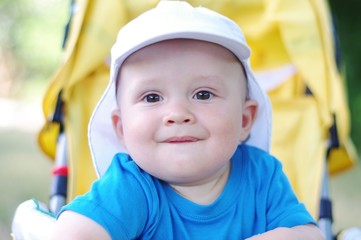 funny baby age of 9 months on yellow baby carriage