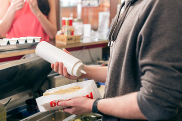 Fototapeta na wymiar Hotdog being diligently prepared by fast food chef